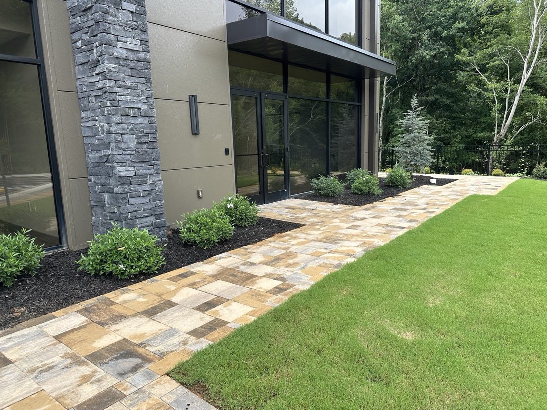 Paver walkway and lawn panel along a modern office building