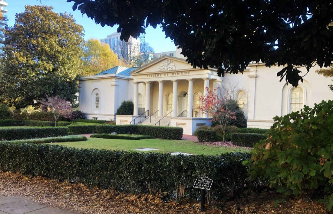 Institutional grounds with clipped hedges and specimen trees