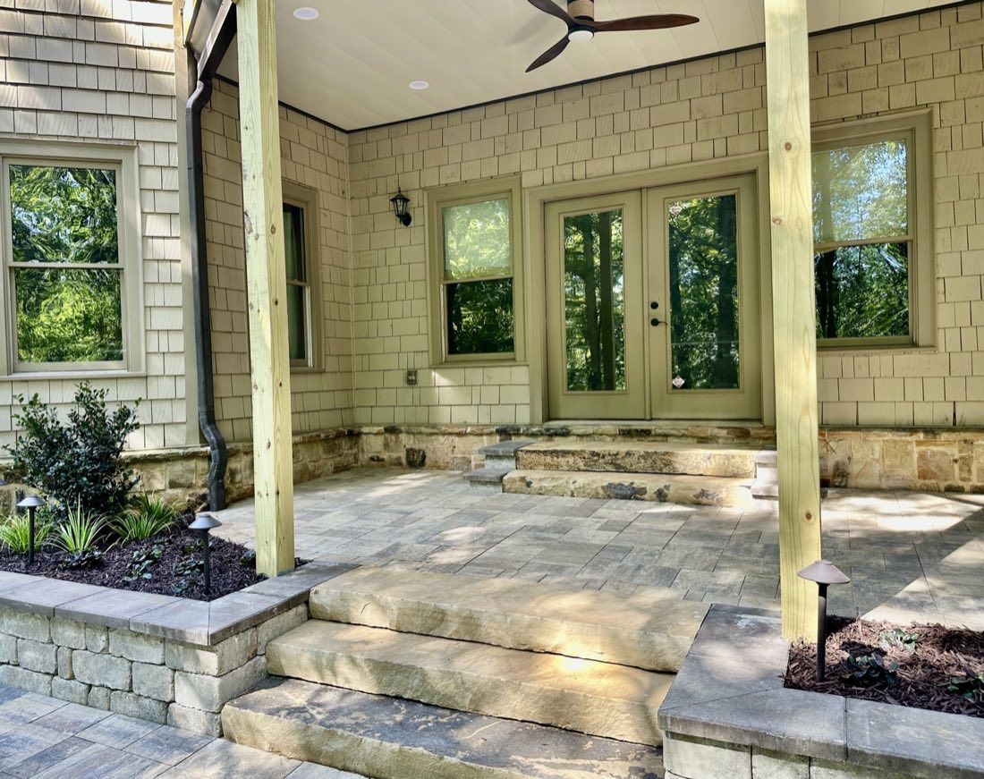 Stone steps and covered patio with landscape lighting