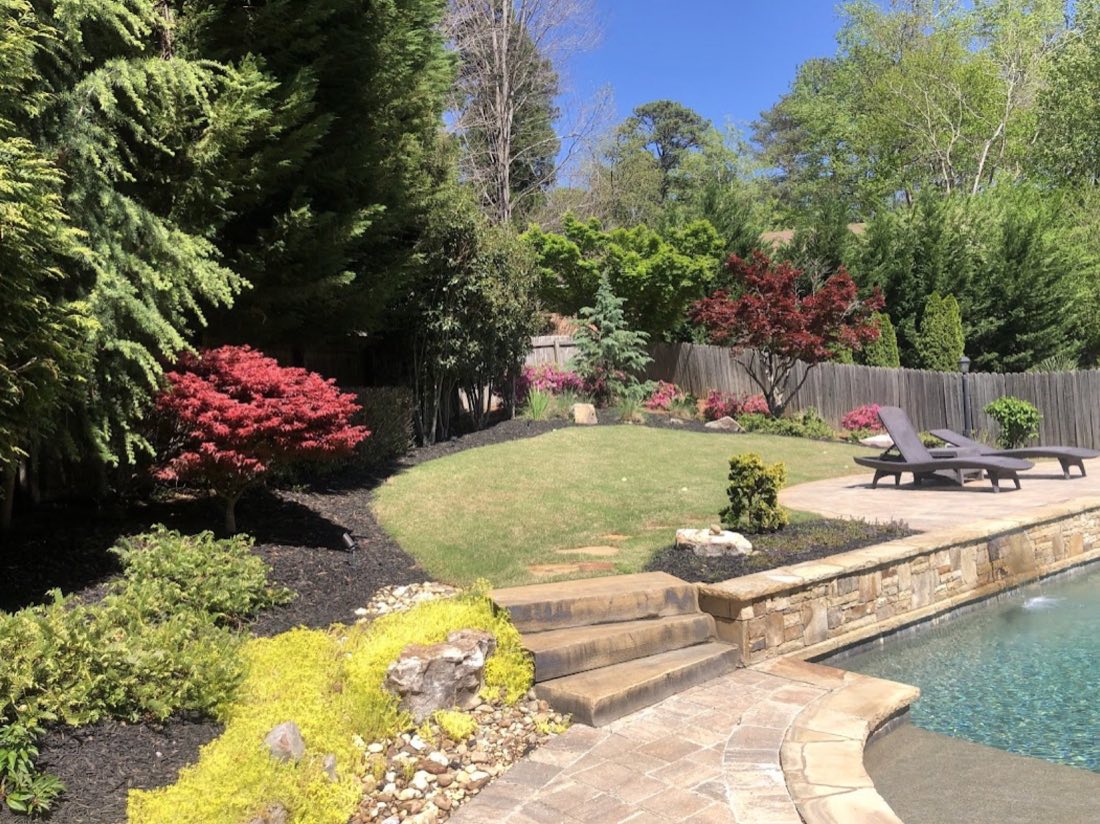 Japanese maples and layered plantings around a backyard pool