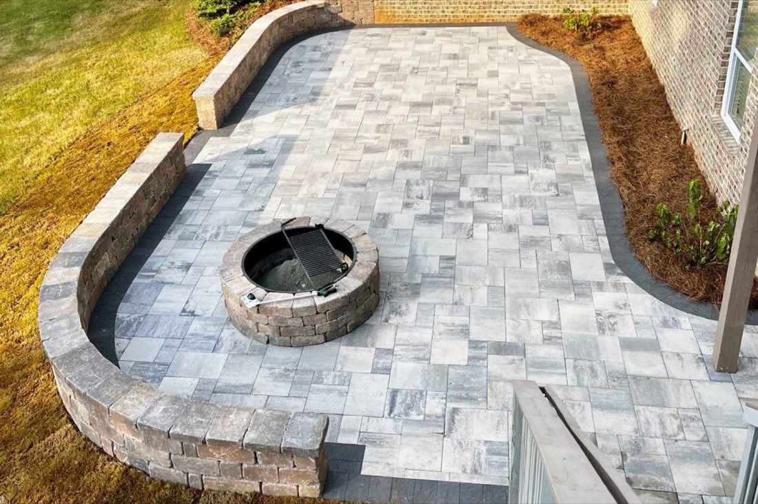 Paver patio with built-in fire pit and curved seating wall