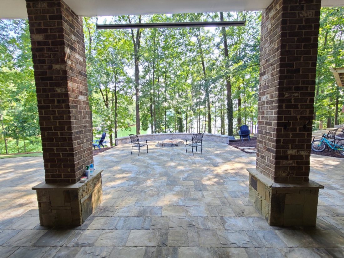 Covered patio under brick columns, overlooking the yard