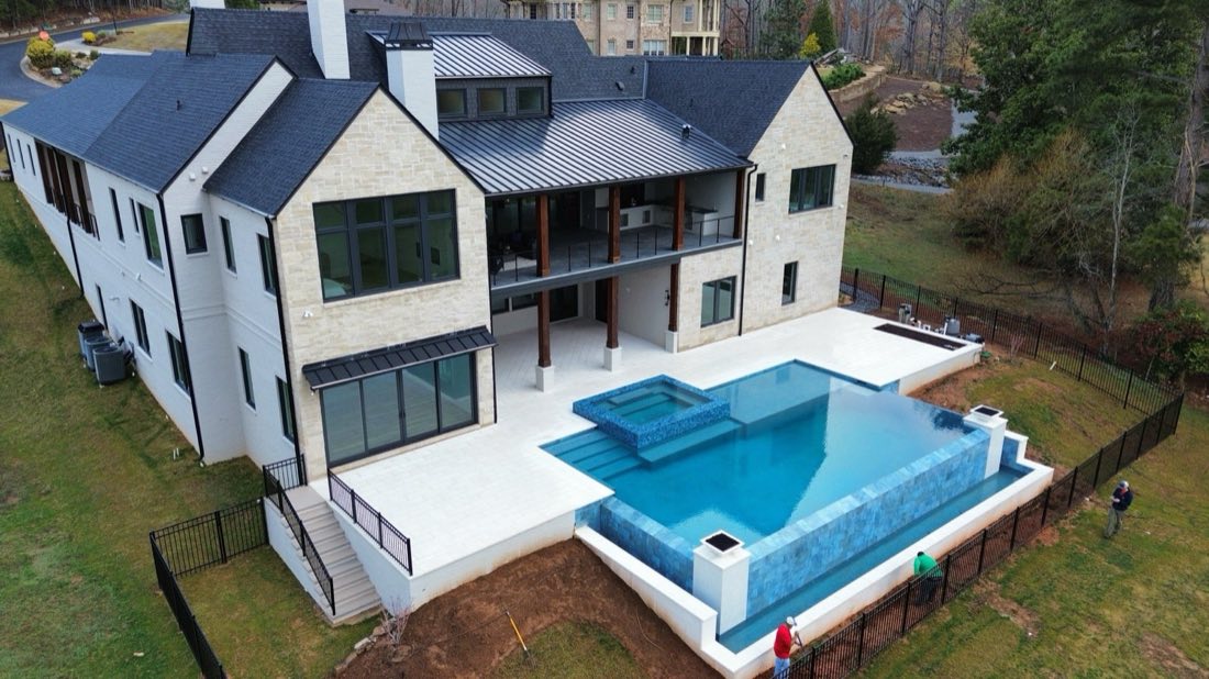 Aerial view — modern home and infinity pool taking shape