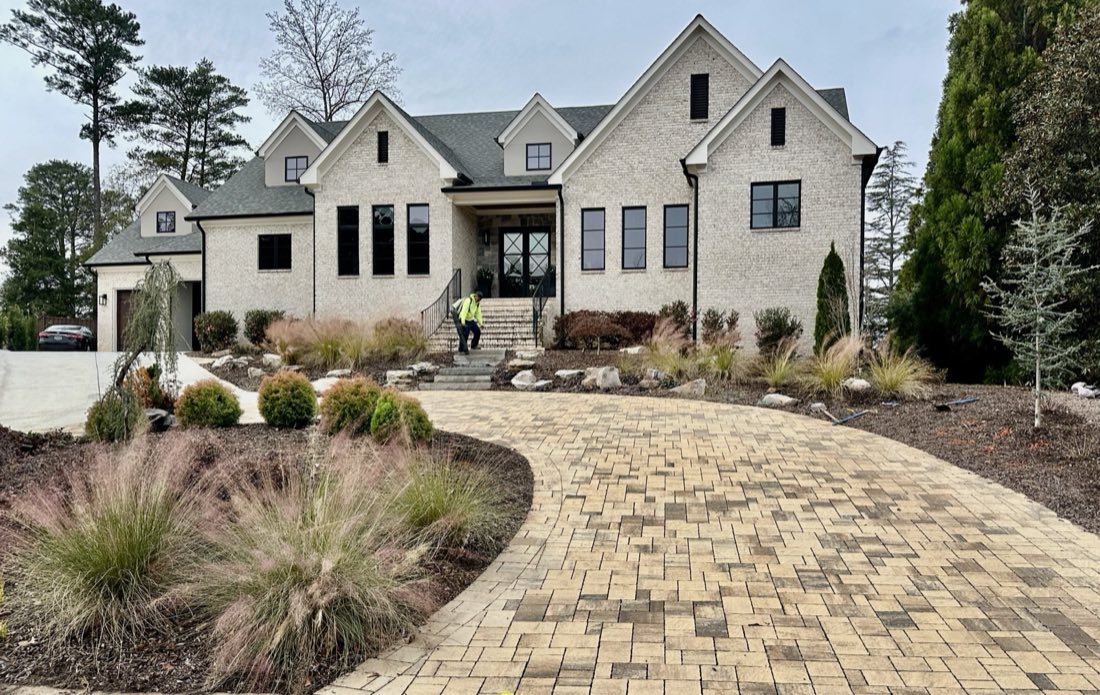 Boulder-accented paver motor court at a new estate